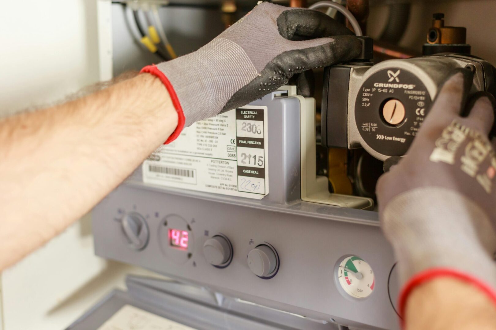 A person is working on an old gas furnace.